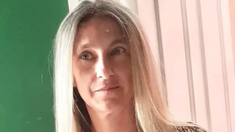 Free school uniform schemes demand is rising Zoe Turner A woman with long blonde hair in front of a green wall and a white wooden door
