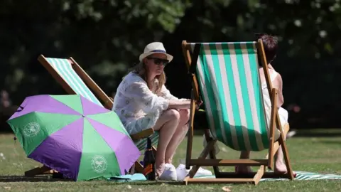 Hot weather to peak amid water shortage fears EPA Londoners enjoy the warm weather at a park in London