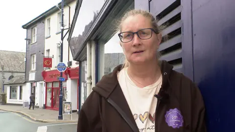 Devon foodbanks say families struggle to feed children in school holidays BBC Chrissie Read has her hair tied back and is standing outside on a pavement leaning against the wall of a shop, wearing glasses, a cream t-shirt and a black hoodie.
