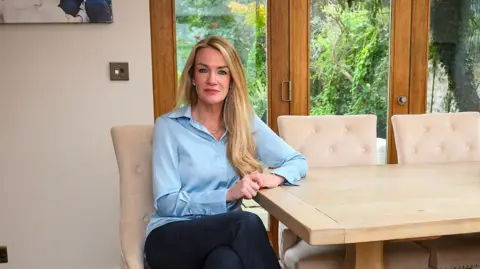 Behind the wave of asylum hotel protests Orla Minihane sits on a beige dining chair at her home