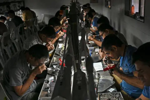 Inside the Indian factories hit hard by US's 50% tariffs PUNIT PARANJPE/AFP via Getty Images Diamond factory workers in Surat in western India
