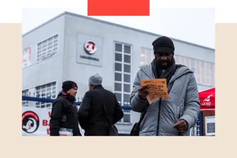 The UK car industry is at a crunch point Reuters/ Chris Radburn A man holds a leaflet as workers protest following Stellantis' announcement of its plan to shut its Vauxhall van factory in Luton