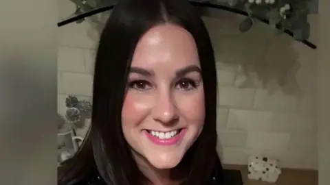 Lucy Connolly released from prison after race hate post on X X.com A smiling Lucy Connolly looking directly down the camera. She has shoulder length, dark brown hair and brown eyes. She is seen indoors, in what appears to be a kitchen, with a white tiled splashback and work surface behind her. The edge of a hob extractor fan can also be seen behind her.