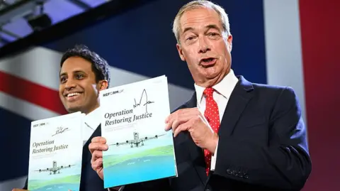 How achievable is Reform's plan on migration? Getty Images Both are smiling and holding up signed copies of their new policy. The document pictures a plane coming to land on a runway, and reads Operation Restoring Justice. Behind them is the top left corner of a large union jack, that is the backdrop to where they are standing.