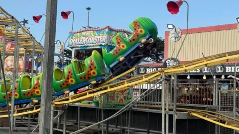 Porthcawl's Coney Beach Pleasure Park accident sees 13 children injured on ride Rebecca Eccleston A side on view of a caterpillar themed rollercoaster where the front of the ride has come off the tracks. It is suspended in the air at the front as the yellow track goes out of the image. Behind there is a sign for a family rollercoaster
