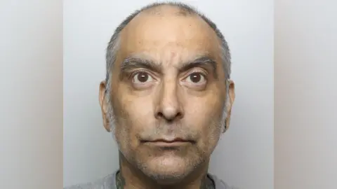 High Wycombe man who shot PC with crossbow jailed Thames Valley Police A mugshot photo featuring a man with large brown eyes and grey eyebrows, with short grey receding hair.