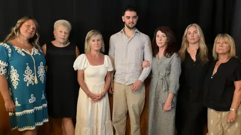 Man saw kaleidoscopic light before going blind Calum standing in the middle of the room as he is flanked on either side by the families of Simone, Kirsty and Cheznye.