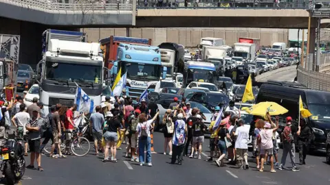 Huge crowds gather in Israel calling for hostage deal and end to Gaza war Getty Images Demonstrators block a road during a protest in Tel Aviv demanding a deal to release hostages detained in the Gaza Strip
