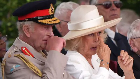 The WW2 veteran who moved Queen Camilla to tears Getty Images King Charles III and Queen Camilla are seated, with the Queen dabbing her eyes, apparently tearful, and the King visibly emotional. The King is dressed in military uniform, while the Queen wears white clothing and a hat