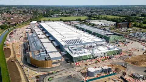 Data centres to be expanded across UK as concerns mount Getty Images A large white data centre building under construction in Hertfordshire, surrounded by green land, a river and housing estates further afield.
