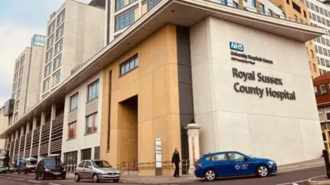 Sussex families feel 'ignored' over Brighton maternity review BBC The exterior of the Royal Sussex County Hospital in Brighton, with the name of the hospital written on the side of the building. A pedestrian is walking into the entrance, being passed by a blue taxi. Several other vehicles are parked on the side of the world.