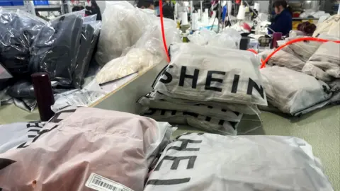 How US shoppers will be hit as the tariff exemption ends Reuters Packs of clothing are pictured at a garment factory for Shein in Guangzhou, Guangdong province, China 1 April, 2025.
