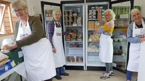 Somerset food banks say demand is rising as donations drop Clare Walsh Volunteers from the West Somerset Food Cupboard are stood in front of a fridge fully stocked with produce