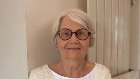 Free school uniform bank in Suffolk 'vital' say parents George King/BBC A head and shoulders image of Fran Tuck. She is wearing glasses and a cream cardigan over a white T-shirt. She is looking into the camera.