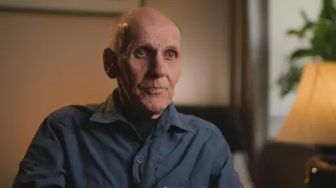 Lives torn apart by fatal crashes on the A9, Scotland's longest road Ronnie Weir, an older man with thinning hair and wearing a dark blue shirt, is sitting in a living room.
