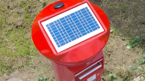 Solar-powered postboxes are being rolled out across UK Royal Mail Bird's eye view of the new postbox design, showing the rectangular solar panel on the red roof of the pillarbox
