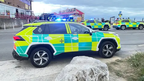 Porthcawl's Coney Beach Pleasure Park accident sees 13 children injured on ride An emergency vehicle is parked with its lights flashing. Two more emergency cars can be seen on the right with a further two police vans in the background. They are parked at the entrance to Coney Beach Amusement Park with the lights from one of the parks buildings in the background.