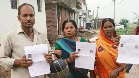 Why India's polling monitor is facing a test of credibility Getty Images A man in a white shirt, and two women wearing blue-green and orange sarees hold up their enumeration forms during the special roll revision exercise in Bihar, India.