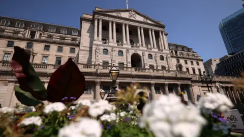 EPA Bank of England building with white and purple flowers in the foreground 