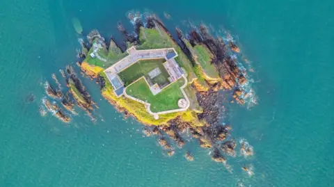 Pembrokeshire's Thorne Island fortress turned into £3m party space Strutt & Parker An aerial view looking directly down on to the island. The stone outer walls surround the majority of the land, with a green courtyard inside. Cliffs and rocks surround it, the sea is turquoise blue.