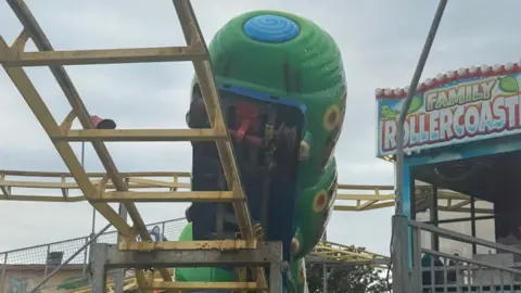 Porthcawl's Coney Beach Pleasure Park accident sees 13 children injured on ride Rebecca Eccleston A fairground ride that has visibly come off its rails as the front carriage hangs in the air. It is a green ride on a yellow track.