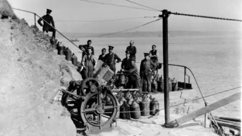 Pembrokeshire's Thorne Island fortress turned into £3m party space Mike Conner A black and white photograph showing a group of men in military uniform on a flight of stairs. A cannon can be seen in front of them, along with a group of metal containers. The sea can be seen behind them.