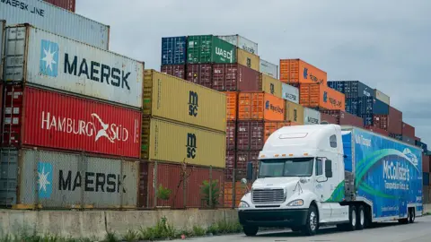 US wholesale prices jump in July as Donald Trump's tariffs hit Bloomberg/Getty A blue and white McCollister's Transportation Group tractor trailer drives past a pile of shipping containers at the Port of Baltimore in Baltimore, Maryland, US, on Friday, Aug 1, 2025.