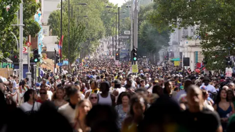 Police to deploy dedicated drone team PA Media A general view of large crowds at Notting Hill Carnival and people filling the street.