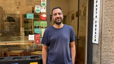 Good Food pasta recipe sparks fury in Italy a man stands in front of a pasta shop
