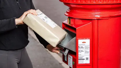 Solar-powered postboxes are being rolled out across UK Royal Mail A Royal Mail postbox showing the drop-down metal drawer and a barcode scanner beneath it.