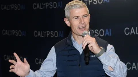 How to stop AI agents going rogue CalypsoAI Donnchadh Casey, wearing a company branded gilet speaks at a conference.