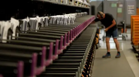 Denmark's state postal service calls time on letter deliveries A PostNord post man helps to sort the mail in a sorting centre