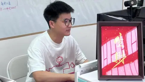 China's unemployed young adults who are pretending to have jobs The owner of the Pretend To Work Company, 30-year-old Feiyu, looking at a computer screen