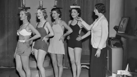 Perfect posture is a myth Getty Images Sylvia Lucie Golledge (right) instructs pupils in the art of correct posture by balancing a glass and book on their heads at her modelling agency and finishing school in Old Cavendish Street, London, 25th November 1936.