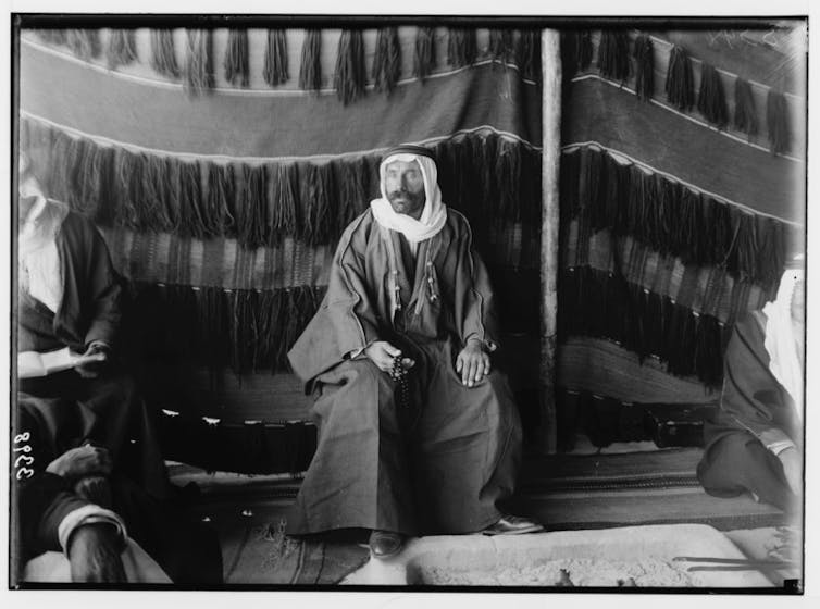 For Syrian Druze, latest violence is one more chapter in a centuries-long struggle over autonomy A black-and-white photograph of a bearded man in robes and a white headscarf sitting inside a tent.