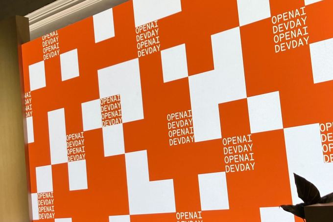 Inside OpenAI’s quest to make AI do anything for you The OpenAI logo on screen at their developer day stage.