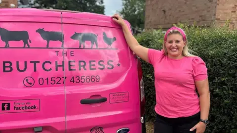 Hagley butcher calls for more support as business folds BBC Rachel Edmonds wears a bright pink T-shirt and Alice band and black trousers and stands next to a bright pink butcher's van, showing her company details and images of animals. She has her hand on the top of the van and she is smiling. A logo on the van reads "the pink lady".