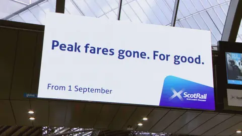Peak time rail fares srapped on ScotRail trains A digital billboard at Queen Street Station in Glasgow says "Peak fares. Gone for good."