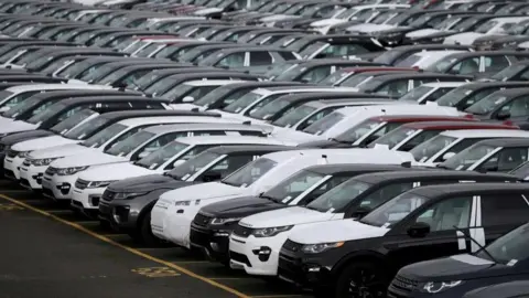 Labour must step up to help JLR supply chain jobs, says Unite Reuters Hundreds of new Land Rovers, some with plastic covers, are seen on a parking lot at a factory in Halewood.