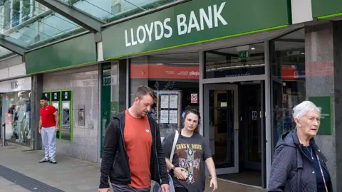 Thousands of Lloyds staff deemed to be underperforming face axe Getty Images People walking outside a branch of Lloyds Bank in Swansea, Wales