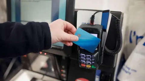 Contactless card payments could become unlimited under new plans Getty Images Man presses a payment card to a reader at a self-service till in a supermarket.