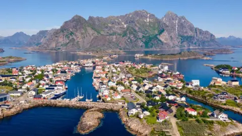 Will drones deliver your next hot food order? Getty Images Aerial view of the village of Hennigsvaer in northern Norway. Houses on islands are in the foreground with a large mountain in the background.