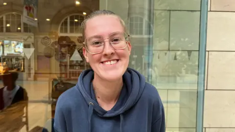 Scotland scrapped peak rail fares Elizabeth Wilson smiling outside a train station