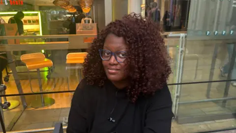 Scotland scrapped peak rail fares Mariama Bundu sat in front of a takeaway restaurant in Paddington