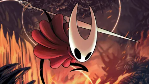 Silksong demand prompts Steam and game store crash Team Cherry The main character from Hollow Knight wielding its sword-like weapon. It is a cartoon insectoid figure wearing a red cape and holding a nail. In the background, flames burn around a forest scene.