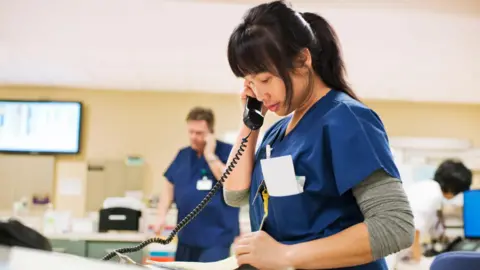 US jobs market weakens further in August Getty Images Nurse in blue scrubs takes notes while on the phone