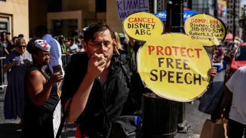 Disney+ cancellations soar after Jimmy Kimmel suspension Reuters A man at a protest holds a sign in the shape of Mickey Mouse's face, which reads "Protect Free Speech" and "Cancel Disney ABC".