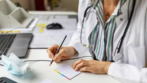The debt advice service helping to reduce GP visits getty stock image of woman writing prescription