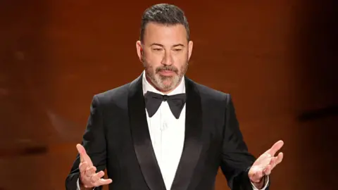 Disney+ cancellations soar after Jimmy Kimmel suspension Reuters A man wearing a black suit speaks with his hands raised in front of him.