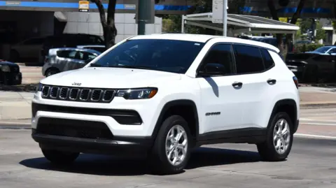 Canada threatens Jeep-maker Stellantis over possible US move Getty Images A mostly white white Jeep Compass SUV with some black trip, The car looks to be driving in an American neighbourhood and takes up most of the picture - some cars and buildings can be seen in the background